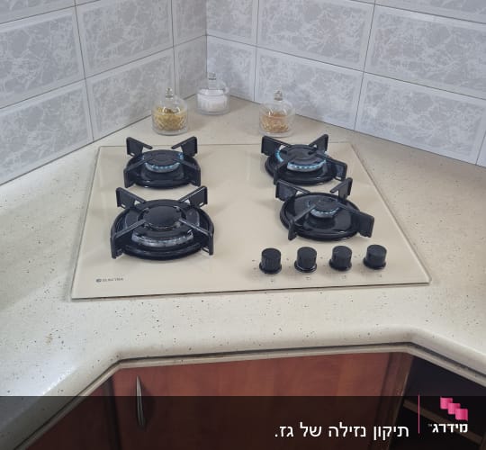 כיריים גז עם ארבעה מבערים וכפתורי שליטה